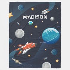 a blanket with the name madison written on it and space themed items around it in blue