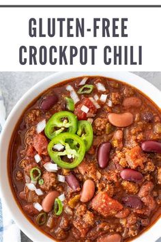 a white bowl filled with chili, beans and green peppers on top of a table