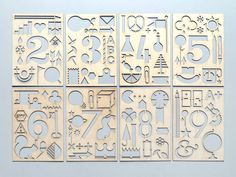 four laser cutout pieces with numbers and symbols on them, all in different shapes