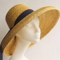 Mirabele Natural Straw Sun Hat with face shading wide brim, deep crown in golden antique colour straw and classic 'darkest navy petersham ribbon decoration. Travel in style. A chic, romantic and versatile hat for country walks, gardening, city strolls and outdoor activities... sea and sand... for summer gatherings. Team up with play suits, printed tea dresses, neutral ensembles, beach wear, trouser suits or smart jeans and wear it all summer long. Limited edition.   SHIPPING All shipments will b Gold Brimmed Straw Hat, Adjustable Gold Panama Hat With Wide Brim, Gold Wide Brim Straw Hat, Elegant Gold Panama Hat With Short Brim, Elegant Adjustable Gold Panama Hat, Gold Brimmed Straw Hat For Kentucky Derby, Gold Wide-brim Straw Hat For Kentucky Derby, Gold Wide Brim Straw Hat For Kentucky Derby, Gold Brimmed Sun Hat For Kentucky Derby