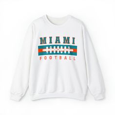 Are you ready for FOOTBALL SEASON?! And are you looking for a unique, retro design that differs from the generic team gear you find elsewhere online? This vintage styled, cute Miami Football sweatshirt is perfect to support your Miami Dolphin this football season! This crewneck is available in white, ash grey, sport grey, heather grey, sand, and black (pick one up for your husband/boyfriend/best friend/dad/mom etc too!) Sweatshirt details are below, and the models in the pictures are wearing lar White Tops For Football Season Streetwear, White Streetwear Tops For Football Season, Team Spirit Logo Print Sweatshirt For Game Day, Team Spirit Sweatshirt With Logo Print For Game Day, Varsity Crew Neck Top For Football Season, Football Season Streetwear Tops With Text Print, Collegiate Team-colored Sweatshirt With Logo, Collegiate Sweatshirt With Team Logo Print, College Fan Apparel Sweatshirt With Logo Print