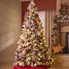 a decorated christmas tree in front of a fireplace with red and white ornaments on it