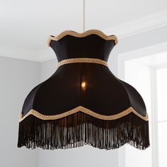 a black and gold chandelier hanging from the ceiling in a room with white walls