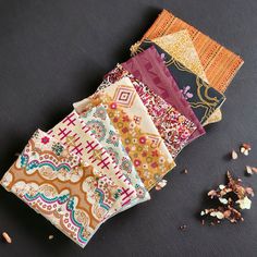 several pieces of fabric sitting on top of each other next to some nuts and seeds