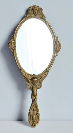 an ornate gold framed mirror on a white wall