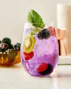 a glass filled with fruit and ice on top of a table