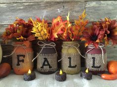 three mason jars with fall decorations in them