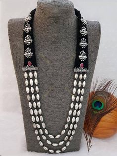 This three-layered Maharashtrian neckpiece, handmade with German silver and coated with silver oxidized plating with beautiful goddess Lakshmi motifs, makes quite an affirmation. This gold-plated silver piece is not so heavy, but it fills your neck with damru shaped beads and adds unmatchable beauty. Pair it with your favourite saree or any Indo- western attires to add a lot of character and elegance to your entire look. As this necklace is handmade, it may have some irregularities or imperfecti Luxury Temple Necklace With Tilla For Navratri, Luxury Temple Necklace For Navratri Celebration, Cutdana Necklaces For Puja And Navratri, Traditional Silver Kundan Mala, Silver Kundan Mala For Festivals, Diwali Celebration Temple Necklace, Handmade Temple Jewelry Beaded Necklaces For Festivals, Temple Jewelry Style Meenakari Mala For Festivals, Temple Jewelry Meenakari Mala For Festivals