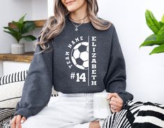 Custom Soccer Team Sweatshirt, Personalized Soccer Ball Sweatshirt, Soccer Sweatshirt, Soccer Ball Sweatshirt, Soccer Mom Sweatshirt Welcome to TEASHIRT2000! **Product Details Our sweatshirts are made from a blend of 50% cotton and 50% polyester, offering a balance of comfort and durability. They feature a medium-heavy fabric weighing 8.0 oz/yd² or 271.25 g/m², ensuring warmth and coziness. The loose, unisex fit makes them versatile for various occasions. **Ordering Process Our ordering process Crew Neck Sweatshirt With Name Print For Sports Events, Long Sleeve Sports Top With Name Print, Long Sleeve T-shirt With Name Print For Sports Events, Long Sleeve Tops With Name Print For Sports Events, Long Sleeve T-shirt With Ribbed Cuffs For Sports, Long Sleeve Tops With Name Print For Sports, Long Sleeve Sweatshirt With Name Print For Sports Season, Soccer Sweatshirt, Team Sweatshirts