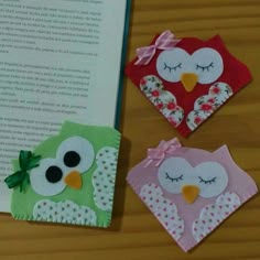 three felt owls sitting next to an open book