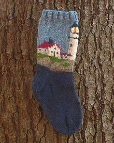 a sock hanging on the side of a tree next to a sign that says knitting socks christmas