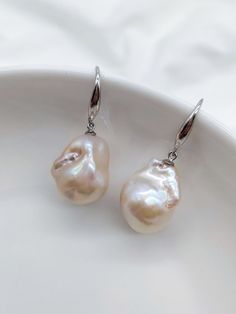 A beautiful new style in our earrings collection. These unique baroque pearls display intense natural colours which are exquisite and varied under different light and angles.  Pearls will vary between each pair of earrings as they are a natural product.   The pearl measures approximately 15mm *20mm * Baroque pearls & Rhodium plated sterling silver With a branded white jewellery box and drawstring pouch for safe keeping, your earrings will arrive in a cardboard box and ribbon for safe transit whi Round Baroque Pearl Charm Earrings, Round Baroque Pearl Earrings, High Luster Pearl Drop Earrings, Silver Pearl Earrings With High Luster, High Luster Silver Pearl Earrings, Pear-shaped High Luster Pearl Earrings Gift, Pear-shaped High Luster Pearl Earrings, Baroque Pearl Teardrop Earrings With High Luster, High Luster Baroque Pearl Dangle Earrings