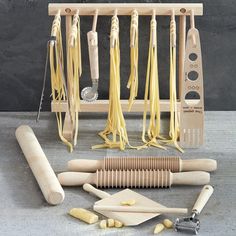 pasta cutters and other kitchen utensils are arranged in front of a wooden rack