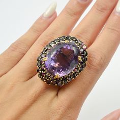 This exquisite ring features a stunning Amethyst as the center stone, its deep purple hue enhanced by the warmth of the yellow gold setting. Surrounding the central gem are meticulously set Rhodolite stones, creating a striking contrast and adding a rich, luxurious feel to the piece. The intricate detailing and the blend of these vibrant gemstones make this ring a true statement piece. Perfect for adding a touch of elegance and sophistication to any outfit, this ring is a must-have for gemstone Amethyst Cocktail Ring, Symbolic Jewelry, Yellow Gold Setting, February Birthstone, Purple Hues, February Birth Stone, Timeless Treasures, Ring Vintage, Cocktail Ring