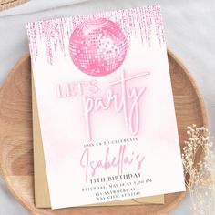 a pink disco ball birthday party card on a wooden plate