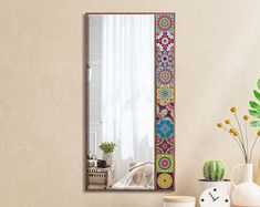 a mirror sitting on top of a table next to a vase and potted plant