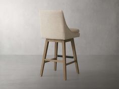 an upholstered bar stool with a wooden frame and backrest, in front of a gray wall