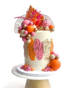 a white cake with orange and pink decorations