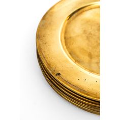 a stack of gold plates sitting next to each other on top of a white surface