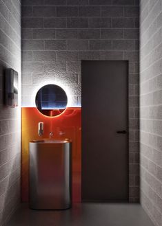 a bathroom with a sink, mirror and light on the side of the wall next to it