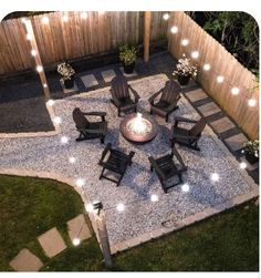 an outdoor fire pit surrounded by chairs and lights