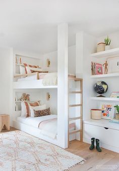 a white room with bunk beds and shelves