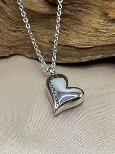 a heart shaped pendant with the words i love you on it, hanging from a chain