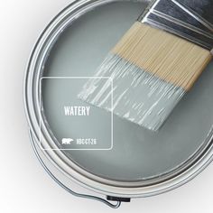 a paint can with a brush in it and the words watery on top of it