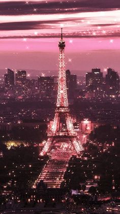 the eiffel tower lit up at night with pink sky in the back ground