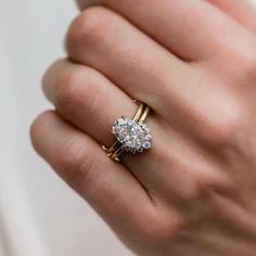 a woman's hand holding a diamond ring