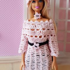 a barbie doll wearing a crocheted dress and hat