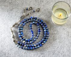 "Product Details * Product Name : REAL Lapis Lazuli 99 Beads Islamic Prayer Beads, Tasbeeh, Misbaha * Material : Natural Lapis Lazuli Stone * Bead Size : 6 mm (Approximately 0,24 Inches) * Bead : 99 pcs * Total Length : 440 mm (Approximately 17,32 Inches) * Length without tassel : 360 mm (Approximately 14,17 Inches) * Colour : As the pictures show * Condition : 100% Brand New Note : The pictures show the real items without any special processing. But the color and brightness may differ a little Hand-strung Round Beads Rosary As A Gift, Hand-strung Rosary With Round Beads As Gift, Hand-strung Rosary As A Gift, Spiritual Silver Beads Mala Gift, Adjustable Mala With Polished Beads As Gift, Silver Mala With 108 Beads As Gift, Gemstone Beads Rosary As Gift, Spiritual Silver Beads Rosary Gift, Gemstone Beads Mala As Gift