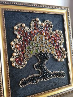 a beaded tree is displayed in a gold frame