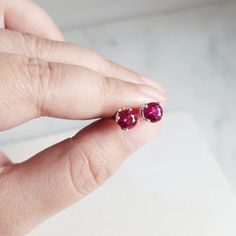 This beautiful pair of handmade stud earrings feature 2 Ruby gemstones. The stud earrings are handmade using nickel-free Argentine Silver. These studs are simple and dainty, perfect for everyday wear. Makes a great gift to add to any gemstone lover's collection. Perfect to gift for Christmas, Valentine's Day, Mother's Day, and more! Gemstone: Ruby, Simulated from Germany Gemstone Size: 6.0 mm Metal: 950 Argentine Silver (Nickel Free) Setting: 4 Prong Earring Back: Pushback **Note** We also sell Fine Jewelry Birthstone Earrings For Everyday, Ruby Gemstone, Earring Backs, Gift For Christmas, Ruby, Mother's Day, Everyday Wear, Great Gifts, Germany