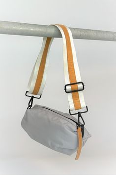 Gray nylon belt bag with white crossbody strap and tan leather detail Track Bag, Fashion Still Life, Sporty Street Style, Lifestyle Accessories, Daily Bag, Straw Bags, Accessories Brand, Orange Bag, Wellness Fitness