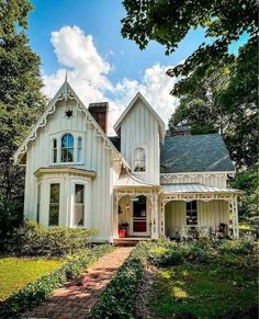 a large white house sitting in the middle of a lush green field