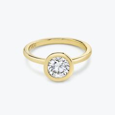 a yellow gold ring with a round diamond in the center, on a white background