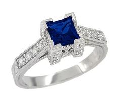 This unforgettable Art Deco filigree antique square blue sapphire engagement ring design is sure to attract admiration as it graces your hand. Artisan crafted in lavish platinum, this unique engagement ring features a splendid natural princess cut sapphire of 0.79 carat, set in an opulent filigree castle setting, with geometric artisan engraving on the outside of the band and shimmery beaded millgrain edging on the sides of the design. The castle setting is embedded with 24 round diamonds, and f Vintage Engagement Rings Simple, Antique Engagement Rings Sapphire, Vintage Inspired Engagement Rings, Blue Sapphire Engagement Ring, Vintage Engagement Rings Sapphire, Round Diamond Setting, Simple Engagement Rings, Sapphire Engagement Ring Blue, Sapphire Engagement Ring