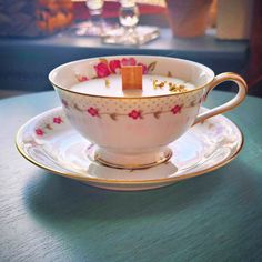 a teacup with a candle in it on a table