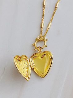 Add a touch of edge to your style with the Patterned Heart Open Locket Necklace. The intricate design pairs perfectly with the delicate heart locket, creating a one-of-a-kind accessory. Ideal for any occasion, the dainty chain adds a subtle touch. Color: Gold Made of: 18k gold plated brass, Lead and nickel-free Brand: Ellison and Young Includes: x1 Necklace Length: Approximately 16" with a 2" extender Elegant Heart Locket Charm Necklace, Elegant Heart Shaped Locket Charm Necklace, Elegant Heart-shaped Locket Charm Necklace, Elegant Heart Locket Necklace With Adjustable Chain, Elegant Charms Locket Necklace For Mother's Day, Elegant Heart Pendant Locket Necklace With Adjustable Chain, Elegant Medallion Locket Necklace For Mother's Day, Elegant Heart Charm Locket Necklace, Elegant Double Heart Charms Necklace