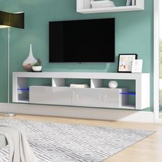 a flat screen tv mounted to the side of a white entertainment center in a living room