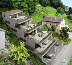 an aerial view of a house on a hill with cars parked in the parking lot