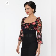 This Sultry Blouse Is Crafted In A Fabulous Black Sheer Stretch Lace Boasting Colorful Florals Throughout. The Scoop Neckline Is Elegantly Framed By Frilled Three-Quarter Length Empire Sleeves. Perfect For Pairing With Your Favorite Bottoms! Imported Shell: 95% Cotton, 5% Spandex ; Contrast: 100% Polyester Hand Wash Cold, Flat Dry Unlined Material Has Stretch & Is Sheer Length Measured From Side Model Pictured Wearing Size M; M Length 20.5" Model Info: Height: 5'9 Waist: 28.5" Hips: 39" Bust: 34 Fitted Flirty Fall Blouse, Flirty Fitted Blouse For Fall, Fitted Flirty Blouse For Fall, Chic Bodycon Tops For Evening, Feminine Fitted Blouse For Night Out, Elegant Bodycon Tops For Evening, Elegant Black Bodycon Top, Elegant Bodycon Tops For Night Out, Elegant Bodycon Top For Date Night