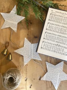 some paper stars are laying on the table next to twine and a christmas ornament