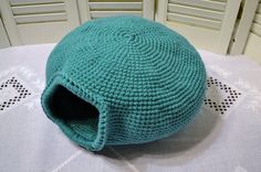 a crocheted blue ball sitting on top of a white tablecloth covered table