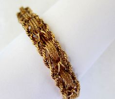 Picture is worth a thousand words,this beautiful 14k solid yellow gold bracelet with intriguing wave and twisted rope chain borders,slide in clasp and safety catch ,weight is 18.4 grams . Height is 1/2 inch,thickness 3 mm,total length from end to end is 8 inches,less 5/16 when closed. Condition like new ,a high quality piece. #729 Elegant Gold Bracelet With Rope Chain, Elegant Gold Rope Chain Bracelet For Formal Occasions, Elegant Formal Gold Rope Chain Bracelet, Elegant Bracelets With Rope Chain And Link Shape, Elegant Bracelets With Link Rope Chain, Elegant Rope Chain Link Bracelets, Elegant Bracelets With Rope Chain Link, Formal Rope Chain Bracelet Jewelry, Formal Rope Chain Bracelet