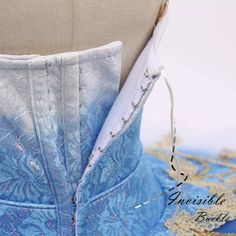 the back of a blue corset with white lace on it's sides