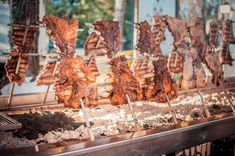 meat on skewers being cooked in an outdoor grill