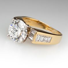 an engagement ring with two baguets on the side, and one diamond in the middle