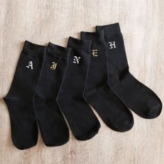 five pairs of black socks with gold letters